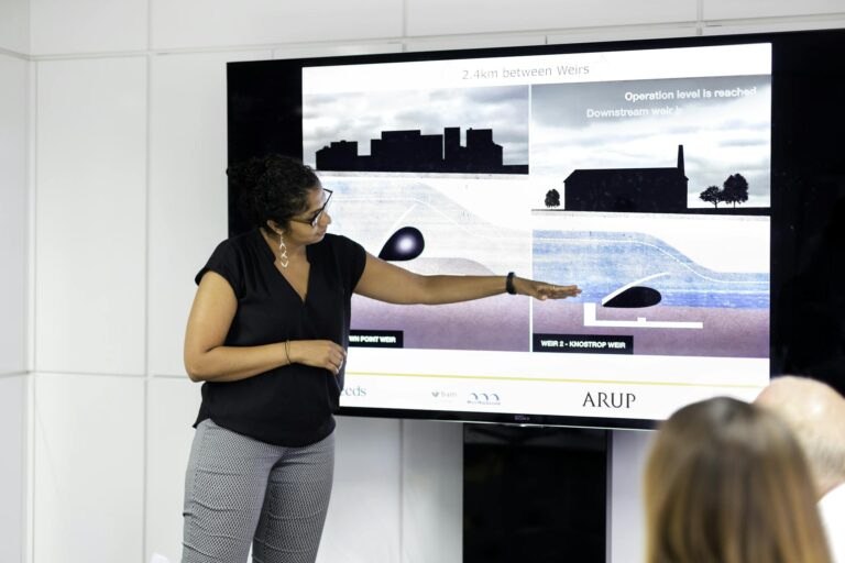 A woman engineer presents a project on weir construction in an office setting.